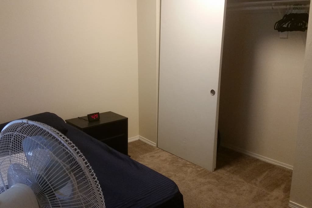 The bedroom also has a large closet with hangers.