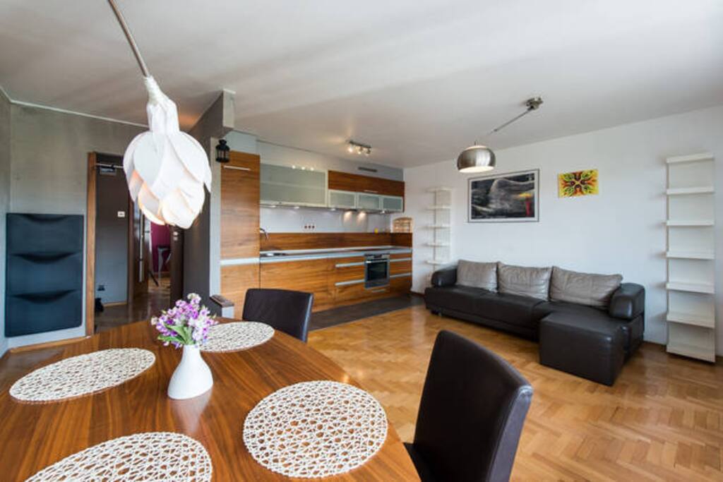 livingroom with dining table, kitchen and sofa bed