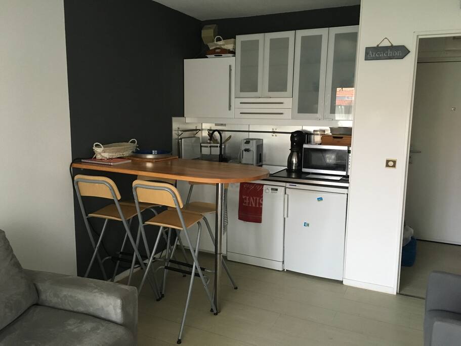 Coin repas et Cuisine américaine avec frigidaire, plaque de cuisson vitrocéramique, four micro-onde grill, et lave vaisselle, cafetière et expresso, grill pain.