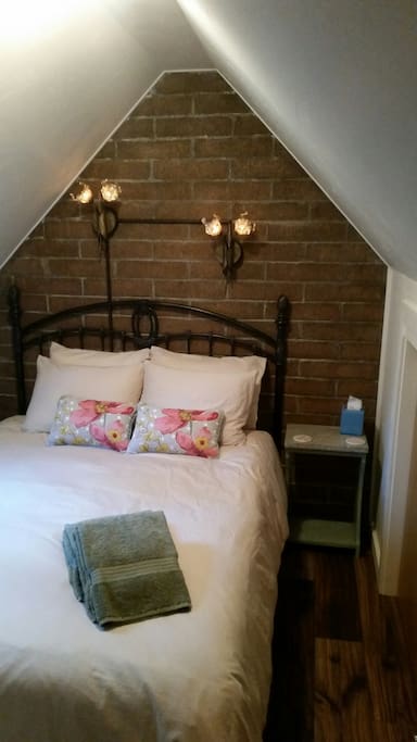 Queen size bed in upstairs bedroom. Also in this room is a sky light and a cozy fireplace heater.