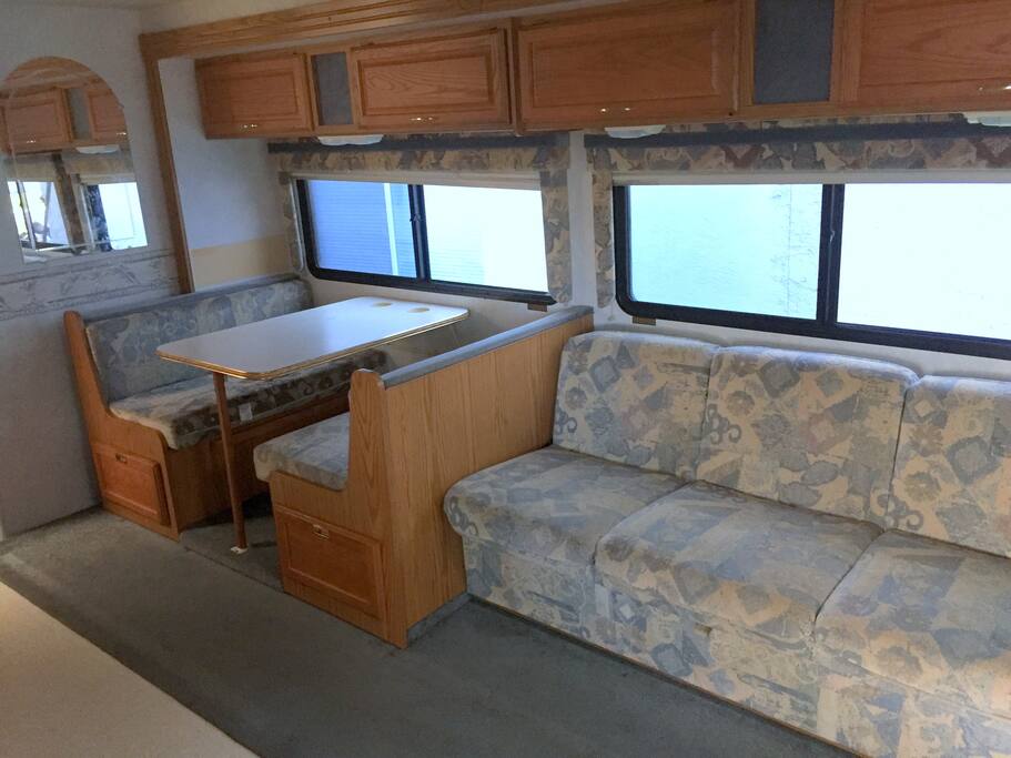 Table & couch with four overhead storage cabinets