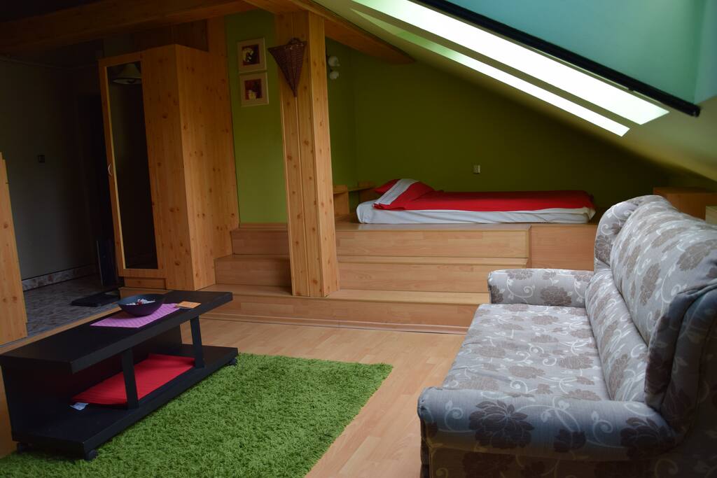 livingroom with pillout sofa and a cozy niche queensize bed place.