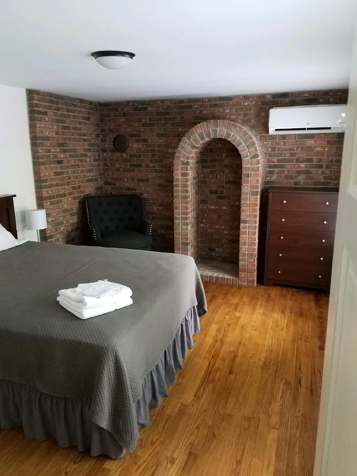 Cada dormitorio tiene sábanas nuevas de alta gama, cesta de lavandería, luces en el armario, vestidor, mesas de noche y outts USB a cada lado de las camas. Dormitorio de ladrillo con silla nueva