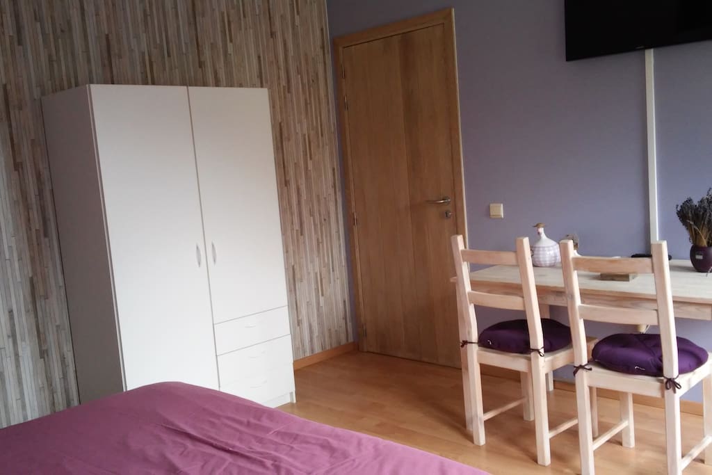 Chambre Lavande disposant d'une table avec 2 chaises, bouilloire avec thé, café.
