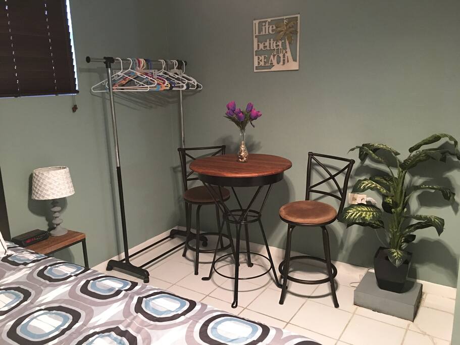 High top refinished wood table with 2 barstools. Suitable for working on a laptop or eating. Newly added clothing rack for additional clothing storage that can be easily moved or taken out of the space if not needed.