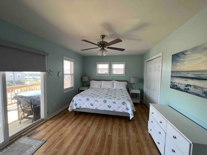 Primary bedroom with a King size bed and its own full bathroom. Also a twin roll away in the closet. Walk out to the deck with a view. 