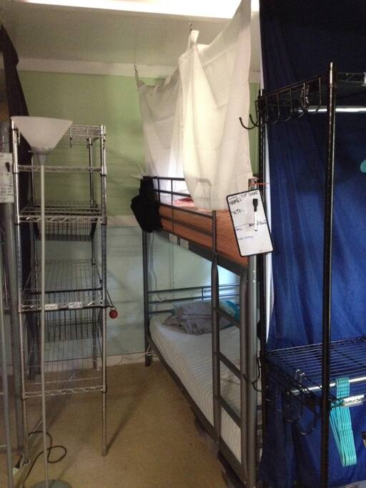 View of the other top bunk in room and storage shelves for guests on bunk beds. Top bunk storage is labeled "TOP"
