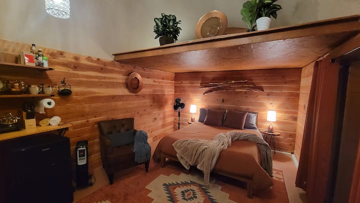 พื้นที่นอนพร้อมฟูกนอนขนาดควีนไซส์ขนาดกลางมีเครื่องทำน้ำอุ่นน้ำมันข้างเก้าอี้นอกเหนือจากเครื่องทำความร้อนแบบพกพาในห้องน้ำ