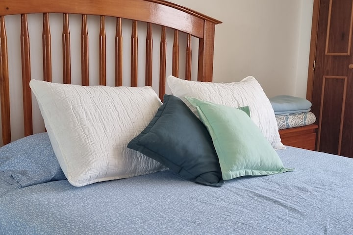 חדר שינה ראשי עם מיטת קווין סייז, חדר רחצה פרטי ושידה. 