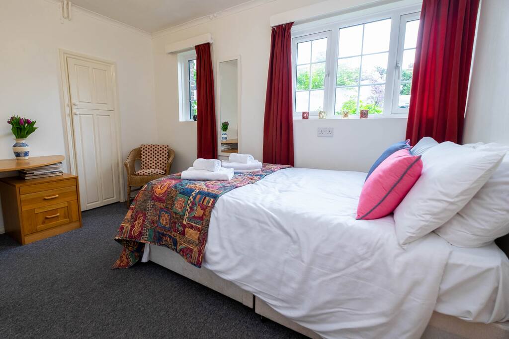 The comfortable double bed is made up with fresh white linen and towels