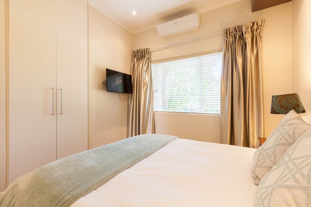 Air-conditioned bedroom with flat screen TV and lap-top size safe