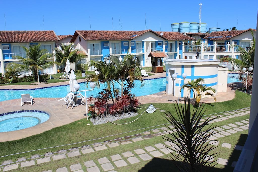 Vista da área de lazer: piscina infantil, piscina principal e sauna.