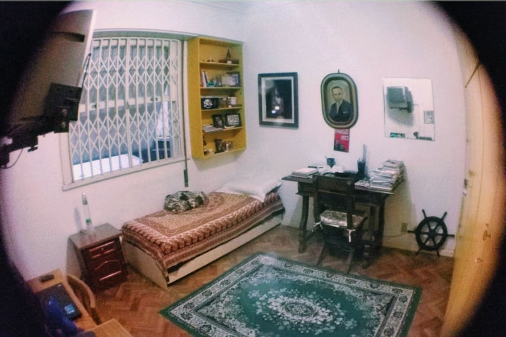 Quarto suíte com cama box, televisão com NET, ventilador, armário espaçoso e duas mesas de trabalho.