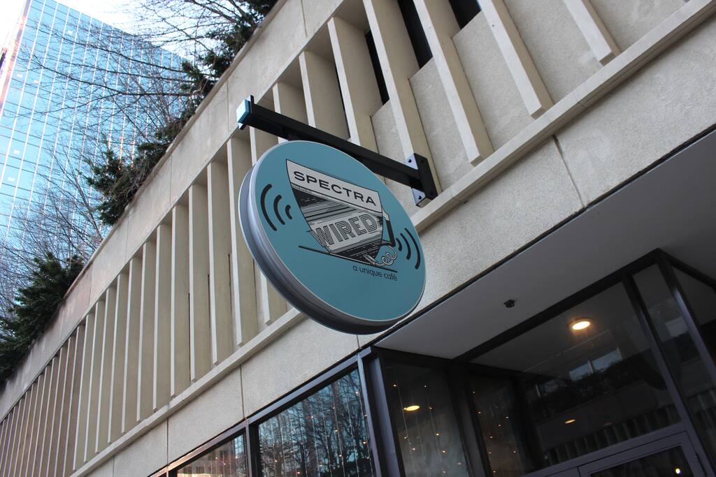 Spectra Logo hanging by the side of the building