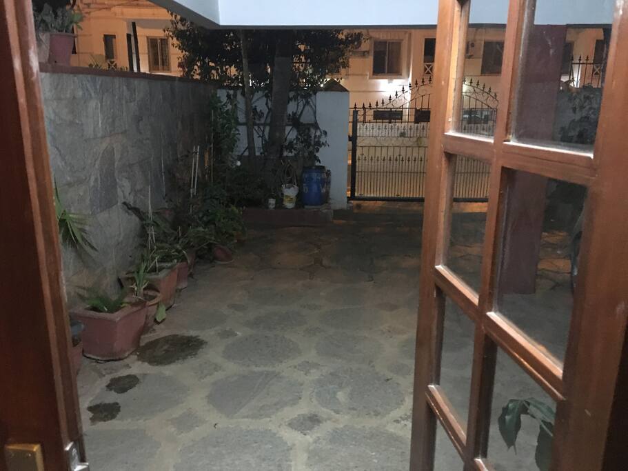 The entrance to the house .the garden with trees and a porch to sit outside and enjoy the lovely climate in peace