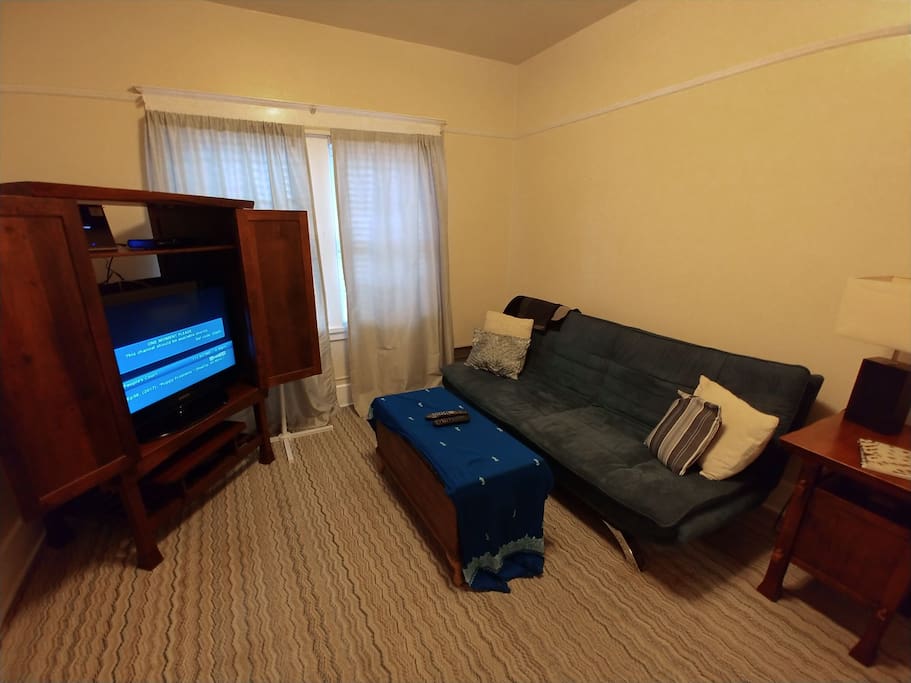 Front living room. Large ~11 x 11 room. Blue futon folds down to full size bed.