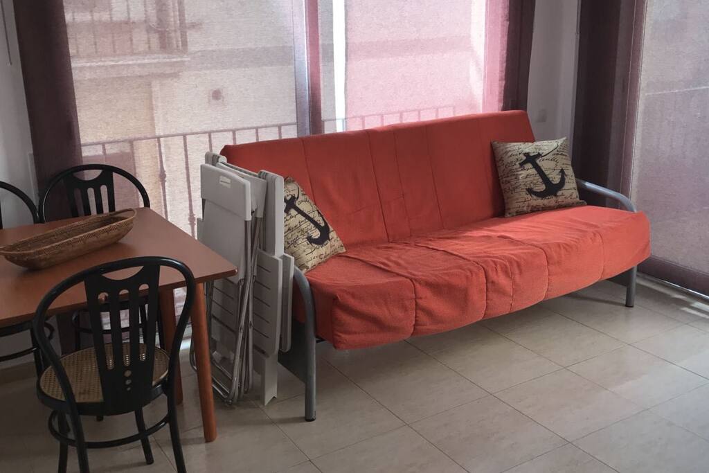 comedor con sofá cama y aire acondicionado.