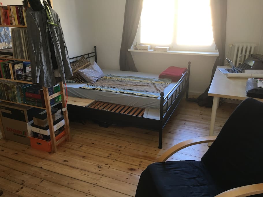 Bett, Bücherregal und Schreibtisch.