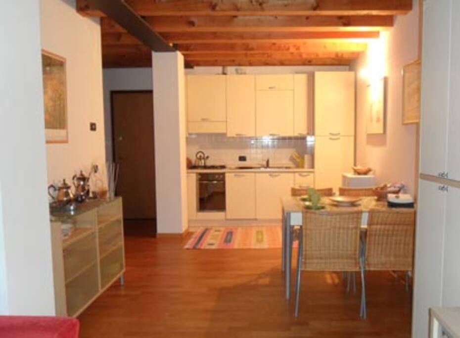 Zona giorno open space con cucina completa di tutti gli elettrodomestici (lavastoviglie, forno, frigorifero, forno a microonde...)