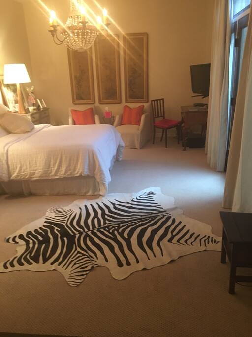 Master has queen bed, conversation area, TV, and desk. Patio door open to a private courtyard.