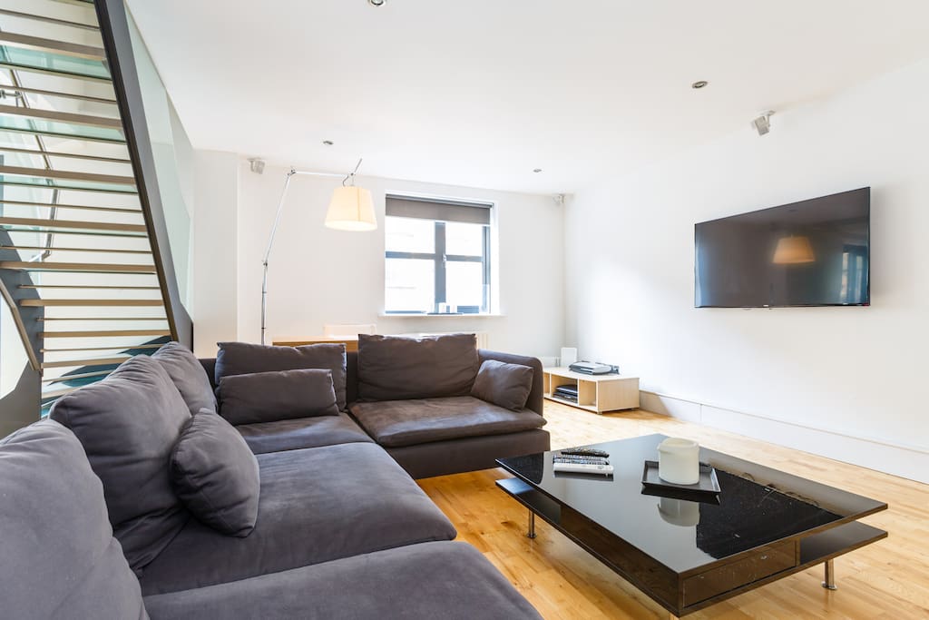 Massive, open plan living area with kitchen, large TV, BOSE sound system, and outdoor terrace.