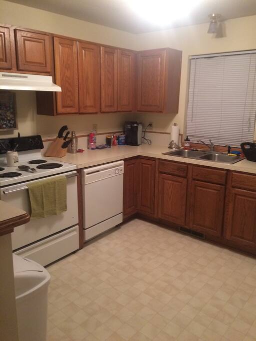 Stocked with dishes, cups, utensils, pots and pans.