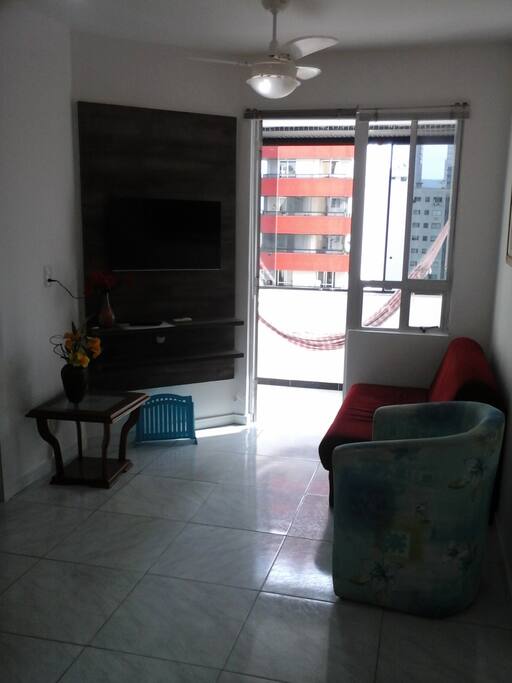 Sala, com sacada fechada e rede de descanso.