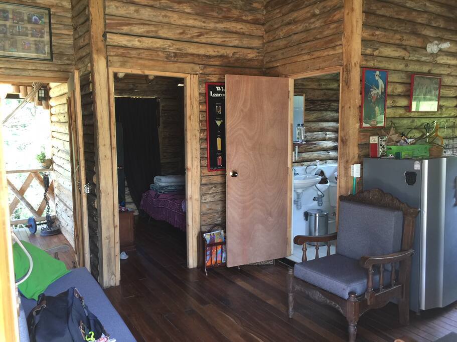 El salón con sofá y sillas con estilo.
A la derecha la cocina, al frente el dormitorio con las dos camas, a la izquierda hay el otro dormitorio con la cama matrimonial, el escritorio y el televisor sobre la pared.