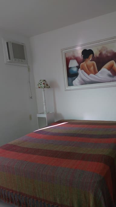 Quarto maior com cama de casal, ar condicionado e armário com 3 portas