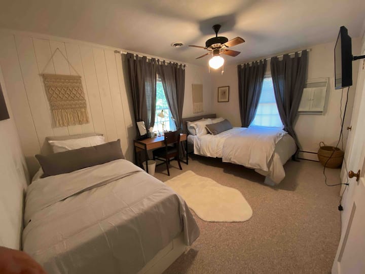 The "Grey Suite" with a queen and twin bed, TV, and a desk.