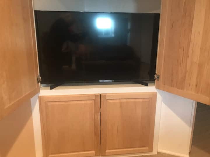 Televisheni kubwa ya skrini yenye Disney Plus, kicheza DVD.