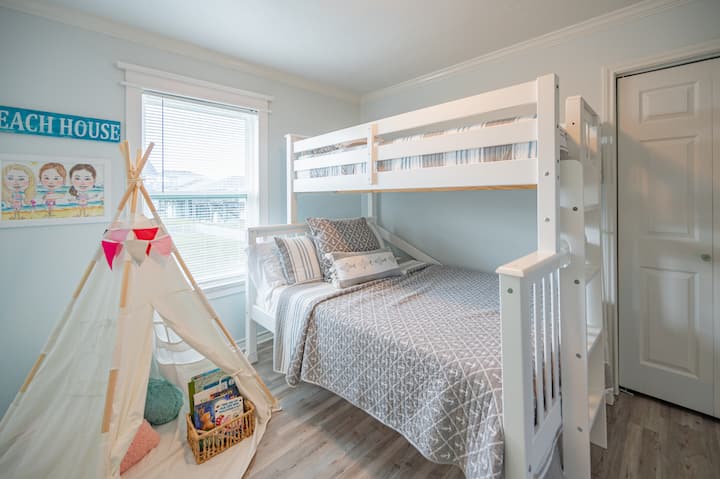 ห้องนอนนี้มีเตียงสองชั้นพร้อมเตียงคู่และเตียงแฝด