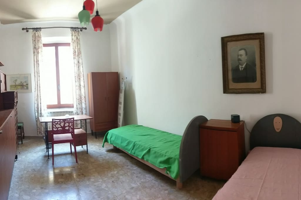 2 Camera da letto: 2 letti singoli, 1 letto singolo estraibile, comodino, lampade, libreria, cassettiera, armadio, scrivania con sedia, poltroncina, specchio intero, asse e ferro da stiro. Lenzuola, copri materasso, copriletto e cuscini forniti gratuitamente su richiesta.