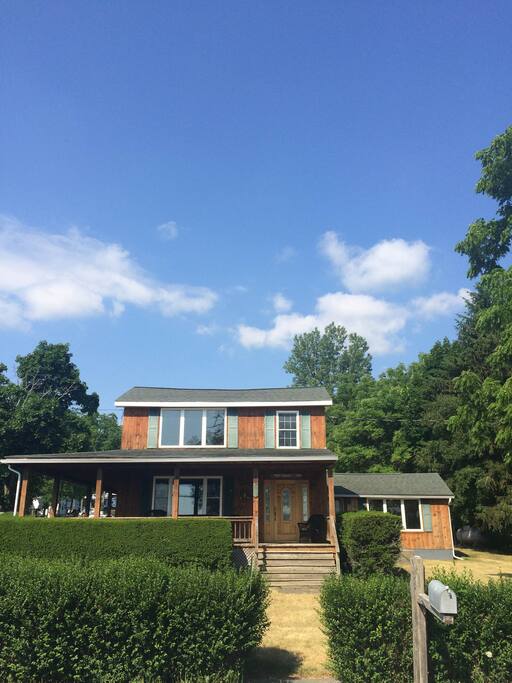 Front of house with wrap around porch faces Cayuga Lake