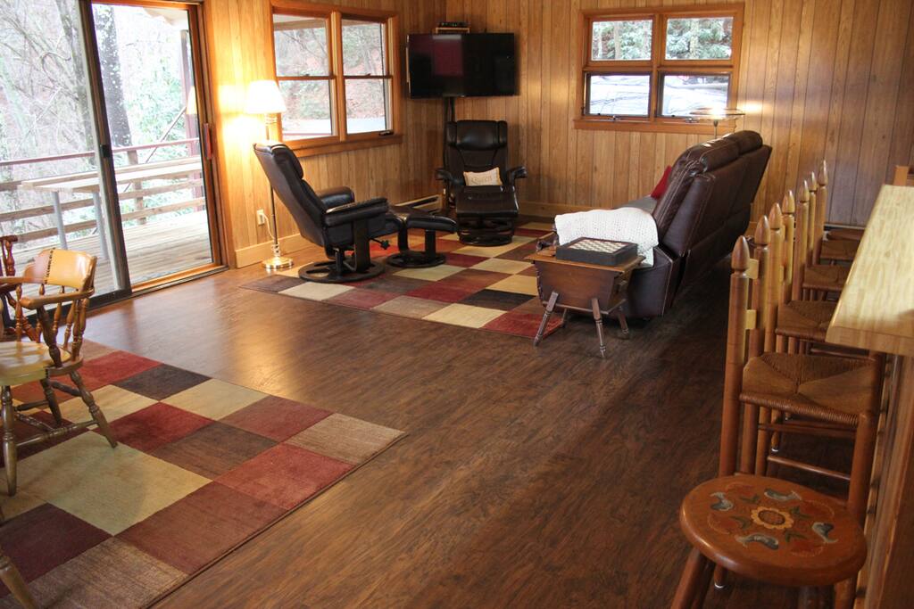 Great room features reclining couch, ergonomic chairs, and flat-screen TV.