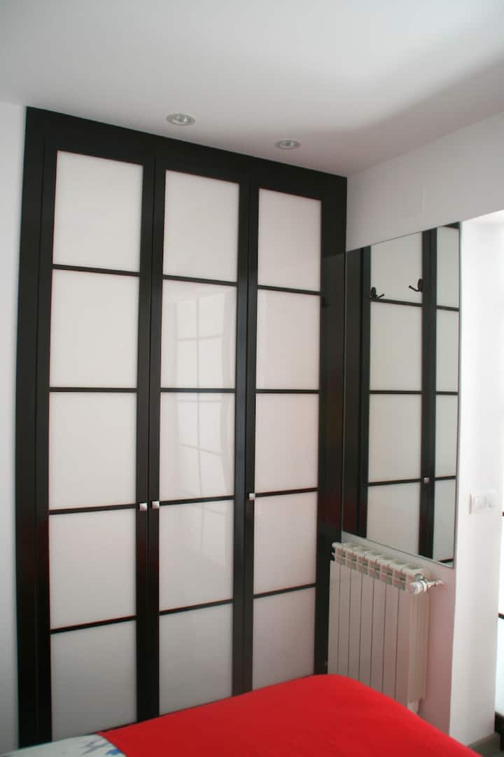 خزانة ومرآة مدمجة مع رف ملابس في الغرفة