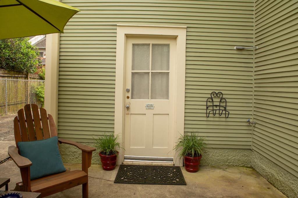 This is your private patio and door to the serene guest suite, located behind wooden fence.