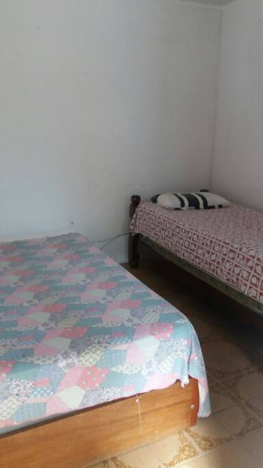 Quarto com uma cama de casal e uma de solteiro
