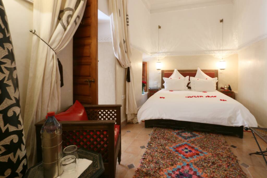 Vista de la cama con un sillon a la izquierda de la foto
