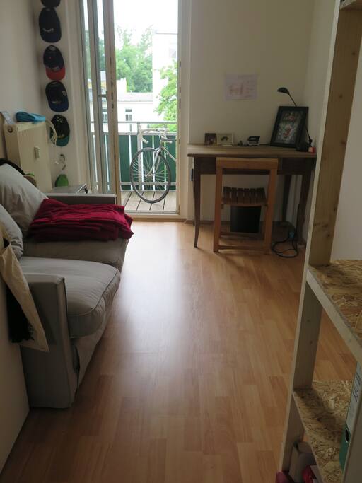 Dein Zimmer mit gemütlicher Schlafcouch und Balkonzugang.