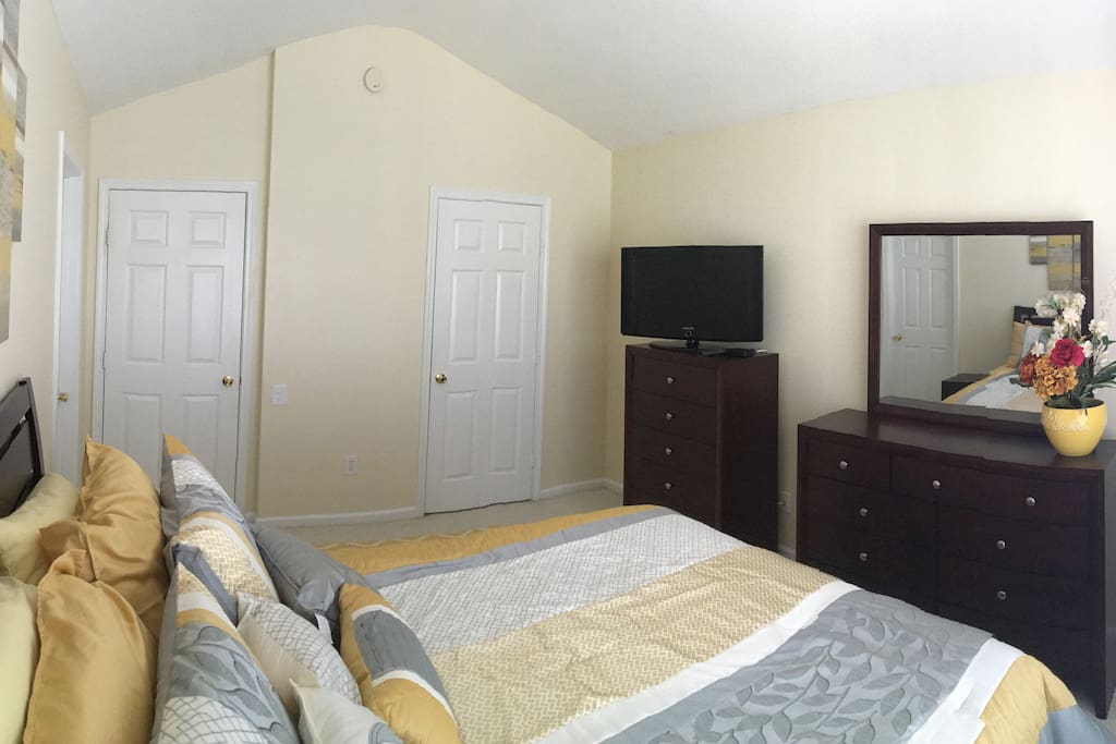 This is the guest bedroom. It includes a flatscreen television with cable, access to a shared bathroom, and a queen size bed.