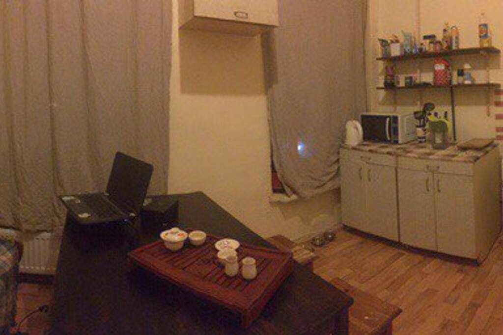 It's our kitchen with gas cooker, kettle, microwave oven, fridge and a washing machine.