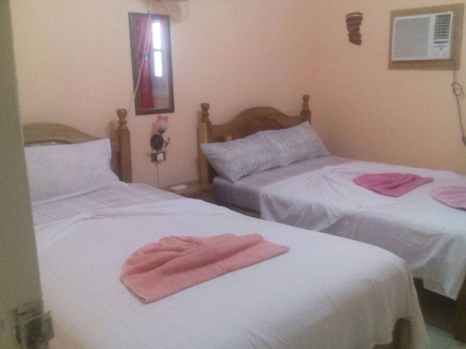 habitación independiente con dos camas mesa de noche y aire acondicionado.