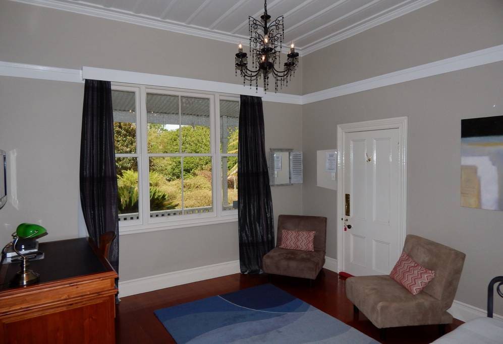 Spacious private lounge with seating, single bed, desk, TV/DVD, fridge, tea/coffee facilities
