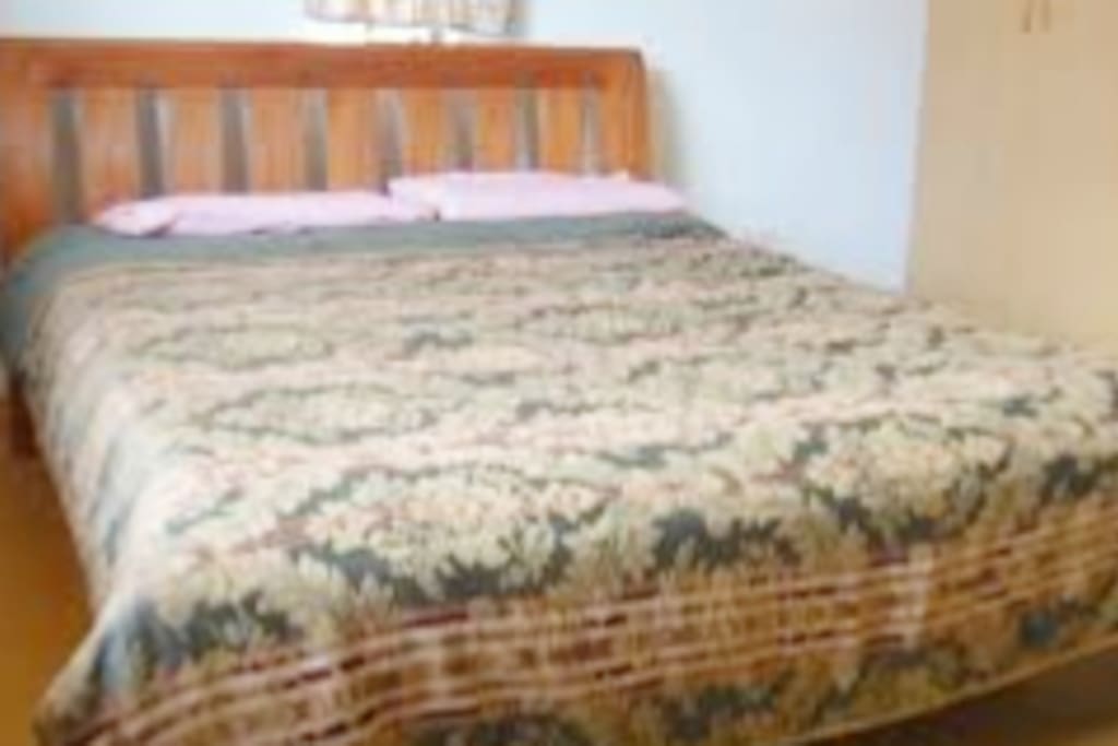 Spacious bedroom with brand new bedding and a TV and sideboard.