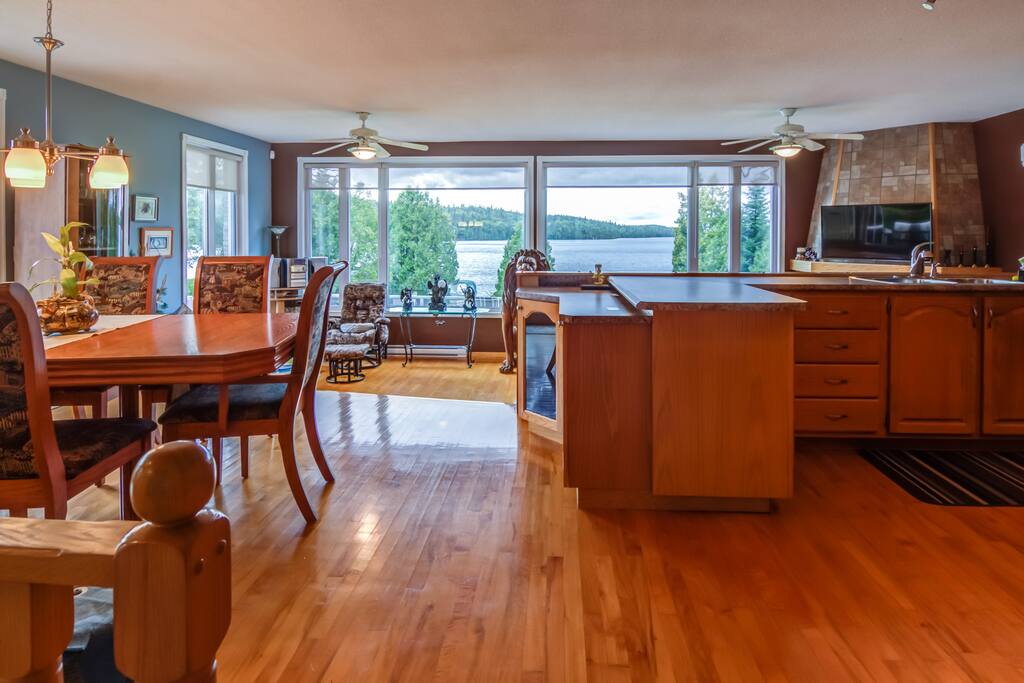 La cuisine, le salon et la salle à manger vous offre la magnifique vue sur le lac.