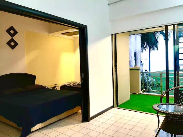 Salpicadura de amarillo en la pared de los dormitorios contra la vista panorámica del campo verde y el mar de azul