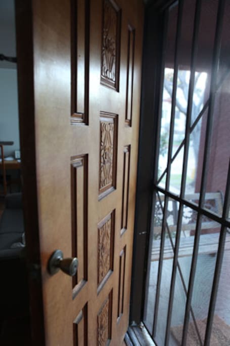 Carved solid wood door welcomes you in. The grill gate allows for privacy but breeziness when you leave the door open.