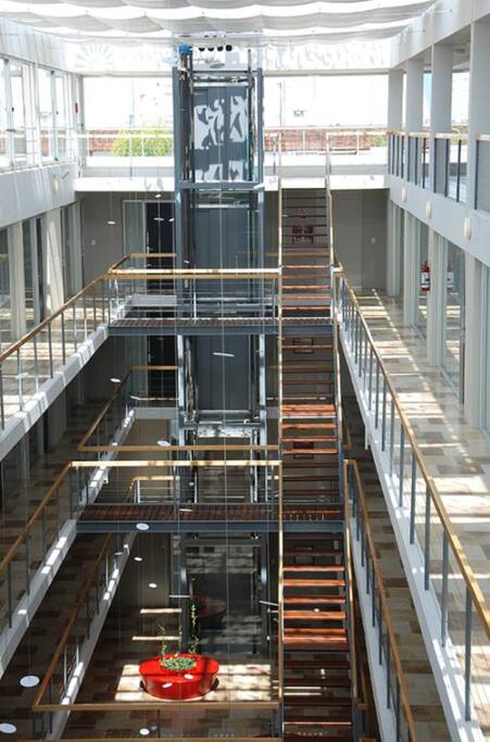 Dos ascensores panorámicos vinculan los cuatro niveles con amplias visuales al patio interior y exterior. Grupo electrógeno para su alimentación e iluminación de emergencia.
Las circulaciones principales balconean sobre un espacio central cubierto (patio interior).