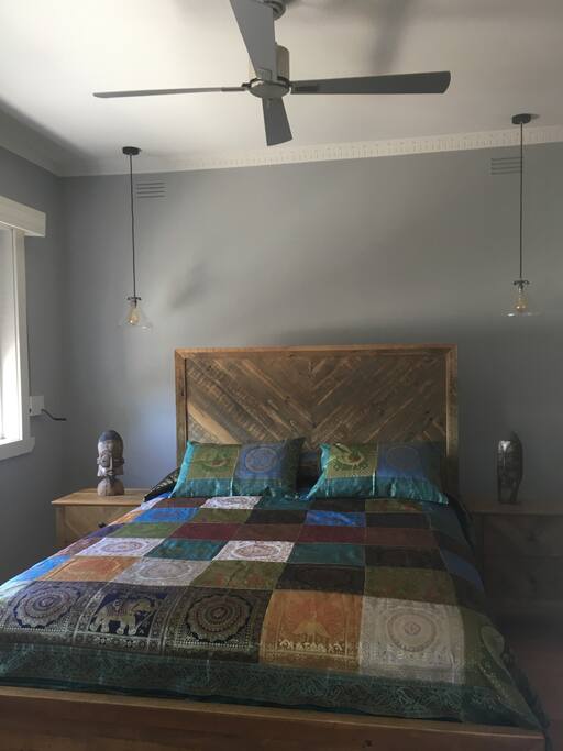 Bedroom with queen bed,side tables, dressing table and storage cupboards.